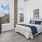spacious bedroom with a bed and windows